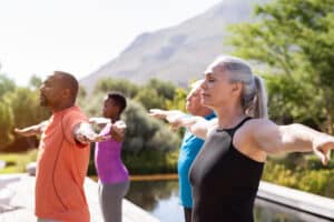 Group,Of,Senior,People,With,Closed,Eyes,Stretching,Arms,Outdoor.